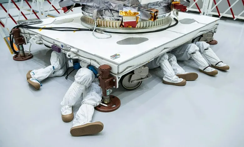 تکنیسینهای ناسا در حال خزیدن زیر فضاپیما