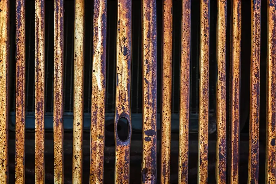 جلو پنجره قدیمی یک خودرو که کاملا زنگ زده است